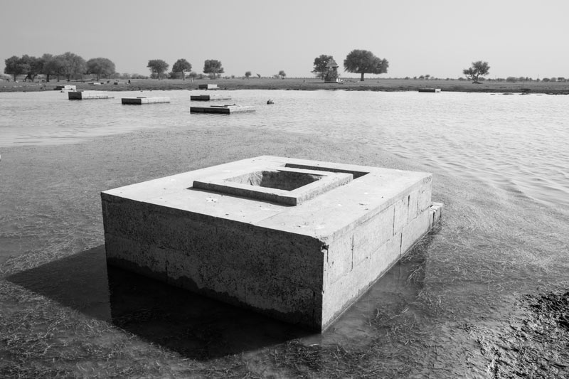 Nature-based solution for quenching thirst in the driest place of India -'Beris'(shallow wells) visible in the receding waters of Viprasar, a rainfed pond in Thar Desert, Jaisalmer district, Rajasthan